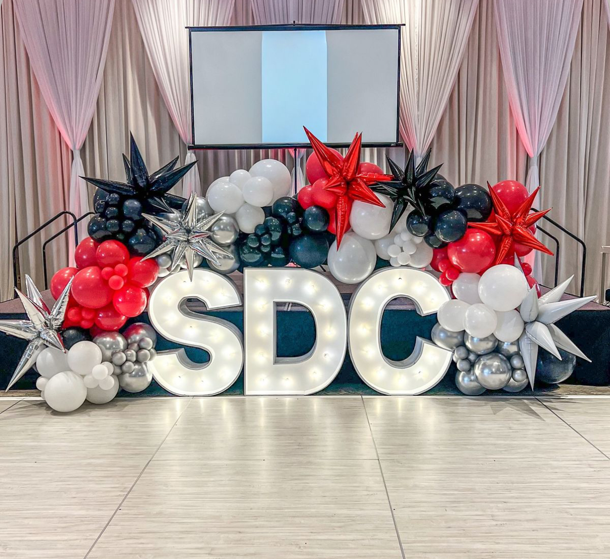 Marquee letters with organic balloon garland at a corporate event